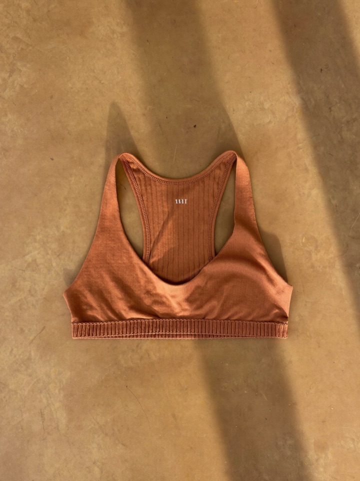 The Sona bra laid flat, showing the ribbed knit and bound edges.